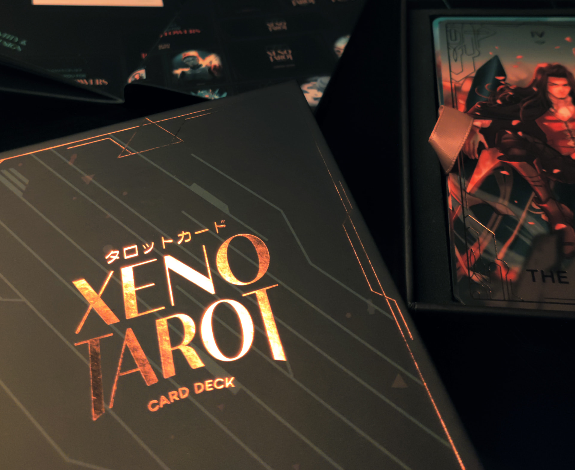 A close up of the gold-foiled logo on the box, with the cards in the background.
