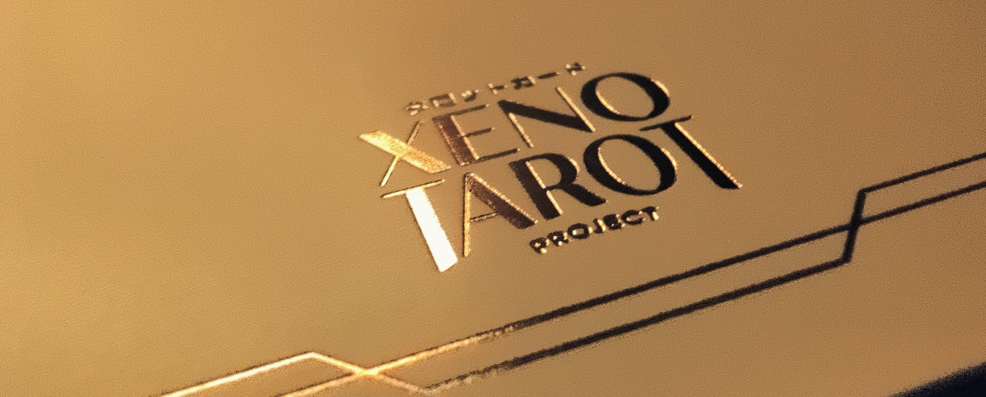 A close up of the logo on the postcard, set in gold foil and shining.